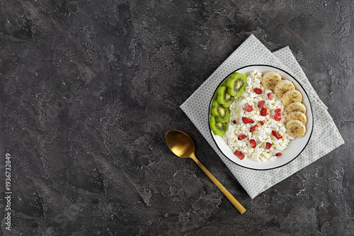 Healthy breakfast bowl with cottage cheese, fresh kiwi, banana slices and dried strawberries
