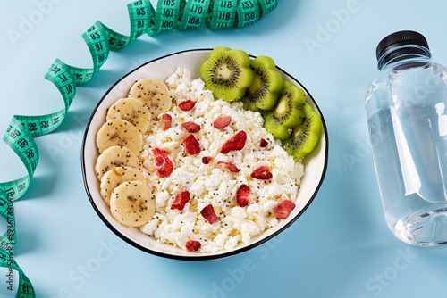 Healthy breakfast bowl with cottage cheese, fresh kiwi, banana slices and dried strawberries