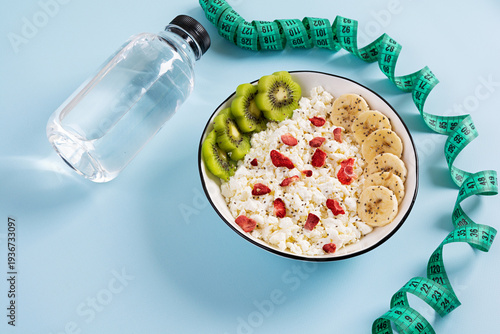 Healthy breakfast bowl with cottage cheese, fresh kiwi, banana slices and dried strawberries