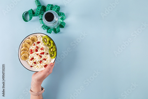Healthy breakfast bowl with cottage cheese, fresh kiwi, banana slices and dried strawberries