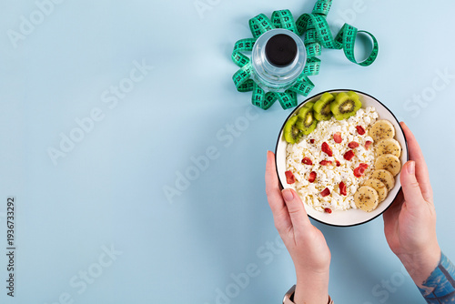 Healthy breakfast bowl with cottage cheese, fresh kiwi, banana slices and dried strawberries