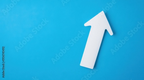 White upward arrow pointing on solid blue background surface