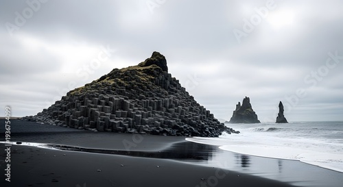 Dramatic basalt columns and black sand beach at Reynisfjara, Iceland, showcasing unique geological formations and powerful Atlantic waves under a moody, overcast sky.