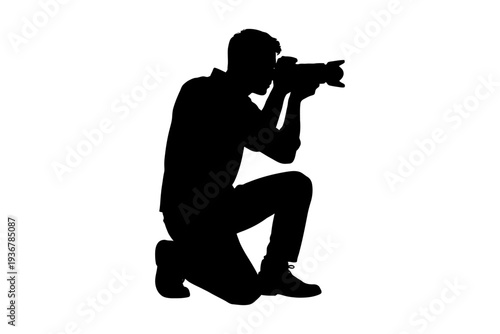 Silhouette of male photographer kneeling with camera.