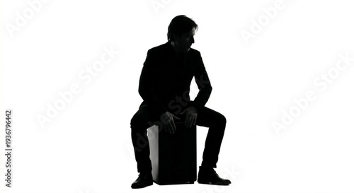 Silhouette of a pensive man sitting on a box isolated on white background
