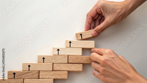 Φωτογραφία Hands assembling wooden blocks with upward arrows in a staircase formation, symbolizing growth, progress, and step-by-step success