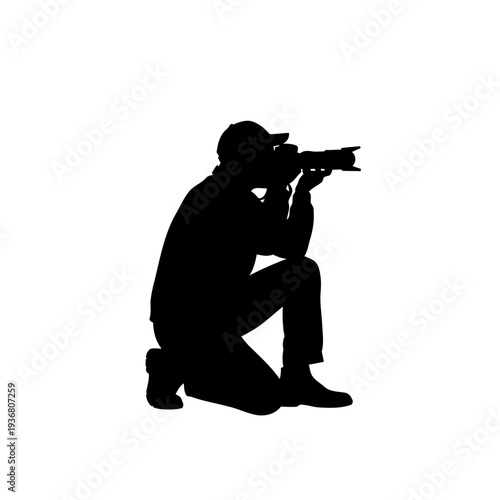 A photographer in a kneeling position taking a picture with a camera