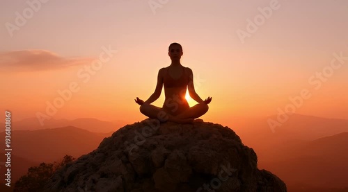 Silhouette of a woman meditating on a mountain top at sunset