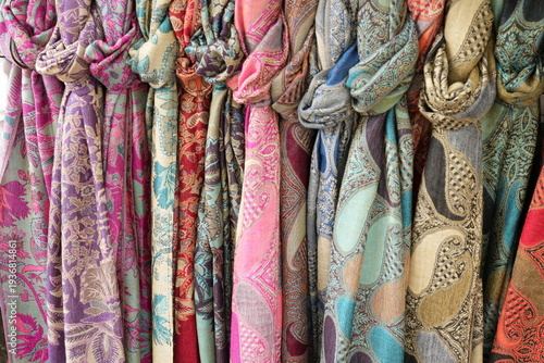 A vibrant collection of colorful scarves in a rich variety of hues, textures, and patterns.