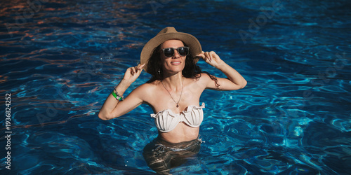 Wallpaper Mural A happy woman relaxing in the pool of a tropical resort. The concept of tourism marketing Torontodigital.ca