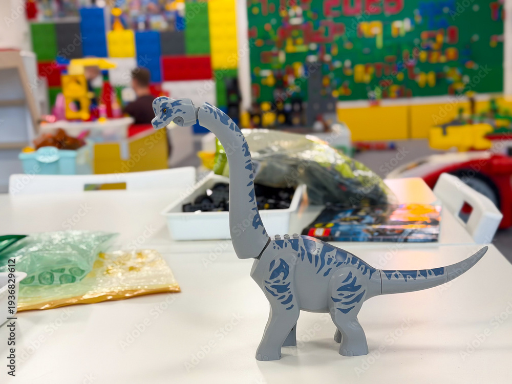 Obraz premium Small gray brontosaurus toy in colorful playroom