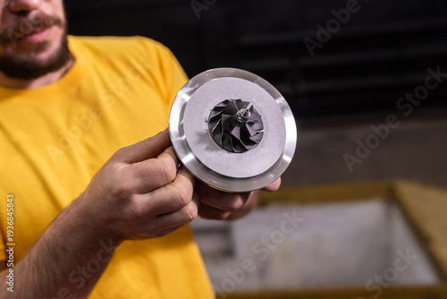 Billede på lærred Mechanic showing new turbocharger cartridge closeup