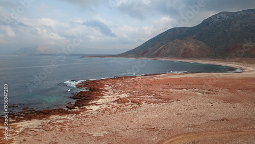 Photos Red sandy crescent beach with mountain backdrop