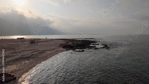 Photos Calm rocky coastline and sandy beach at dusk