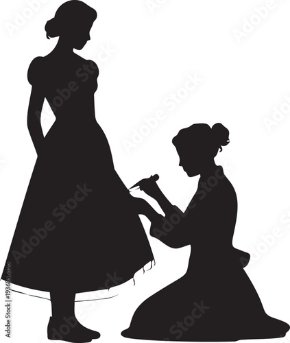 Dressmaker kneeling to adjust a dress worn by standing woman