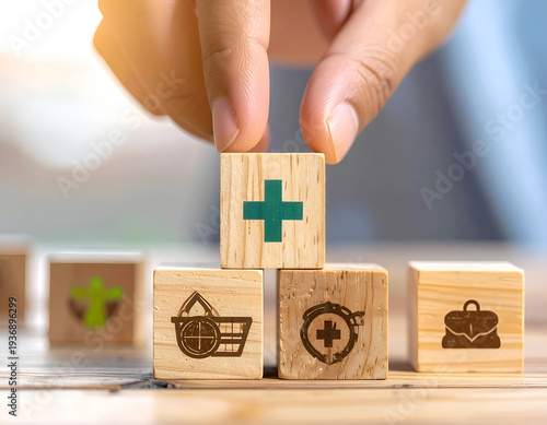 Hand stacking wooden blocks with health symbols on table