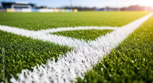 Corner view of artificial grass soccer field with white lines under bright sunlight