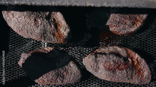 Top down shot of briskets sitting on the grate of a smoker