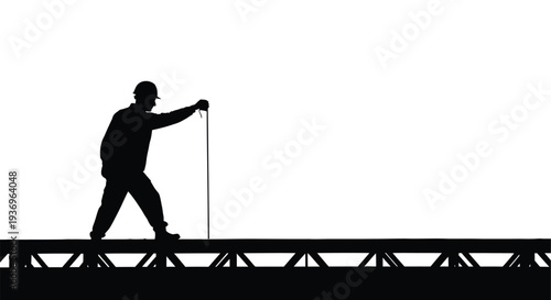A solitary figure walks along a railway track seemingly surveying the lines ahead depicted as a silhouette high quality