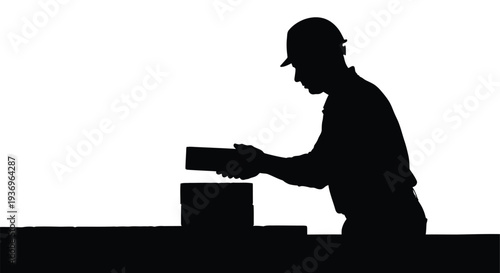 A stark black silhouette depicts a construction worker examining a brick on a ledge highlighting industrial labor silhouette