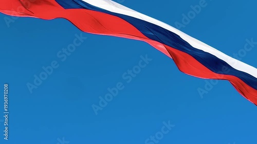 Large flag of the russian federation fluttering in the wind against a clear blue sky