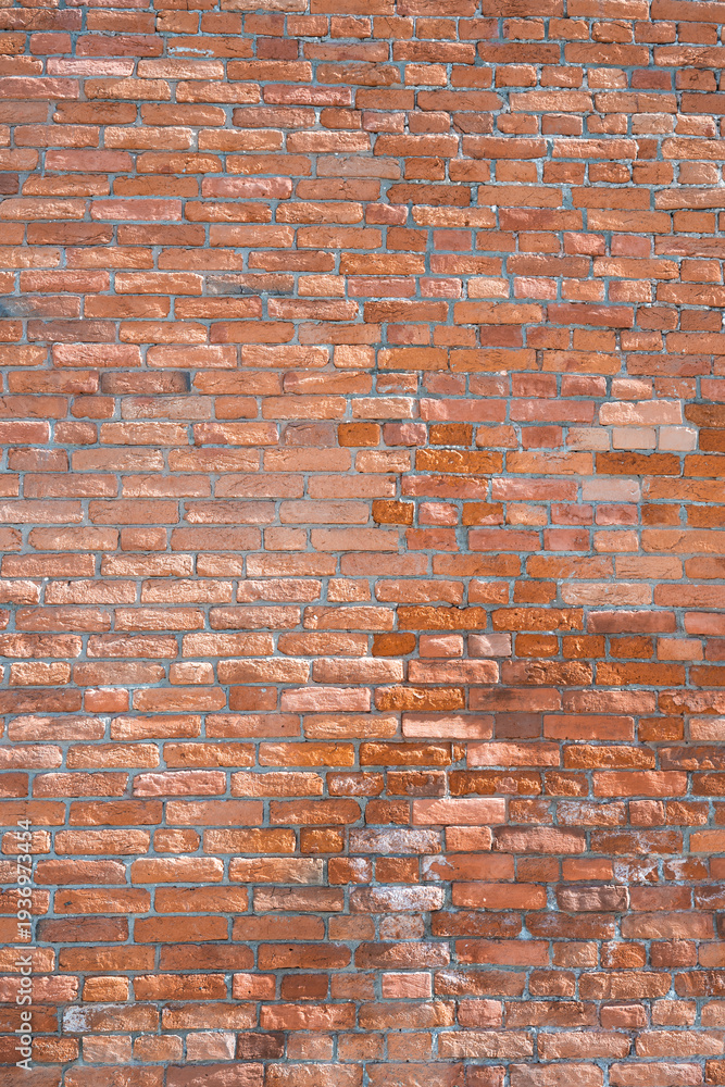 Naklejka premium Close-up of red brick wall texture for background. Modern loft interior with vintage brickwork surface. Vertical shot .
