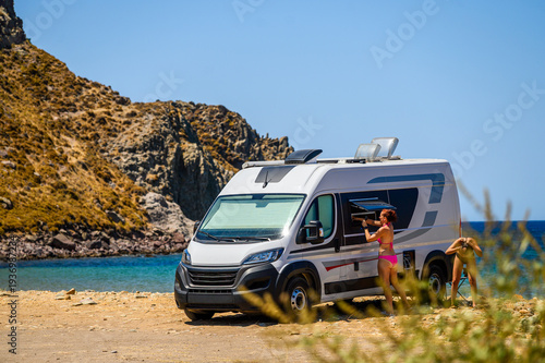 Принти на полотні Women showering next to camper van during free camping on Limnos Island, Greece