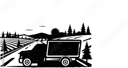 A truck with a trailer travels on a road through a landscape with rolling hills