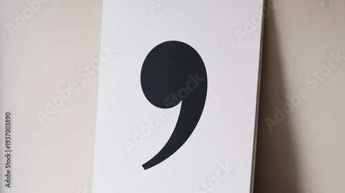 Large black semicolon punctuation mark on white paper background