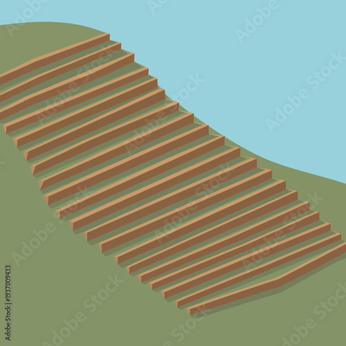 Wooden stairs leading up a green hill against a blue sky.