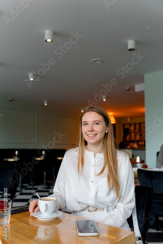 Smiling Woman Enjoying Coffee Break at Cafe Table