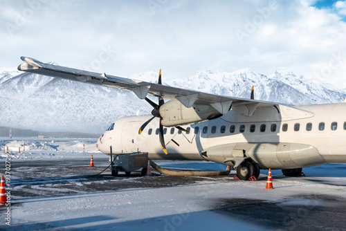 Photography Close-up of the white passenger turboprop plane on the winter airport on the bac