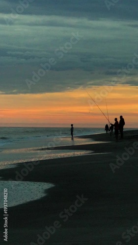 Silhouette of Fisherman Fishing from Shore in the Sea During Sunset a Summer Day on the Beach