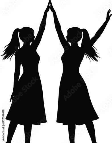 Black silhouette of two happy twin girls wearing dresses with ponytails holding hands up in a celebration of friendship and success