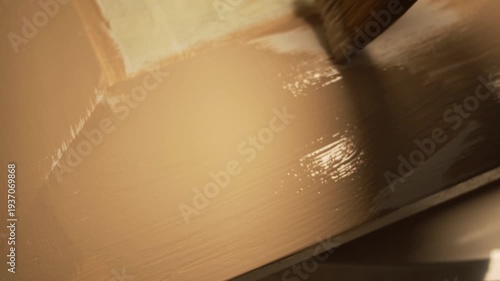 Picture restorer painting a glass frame.