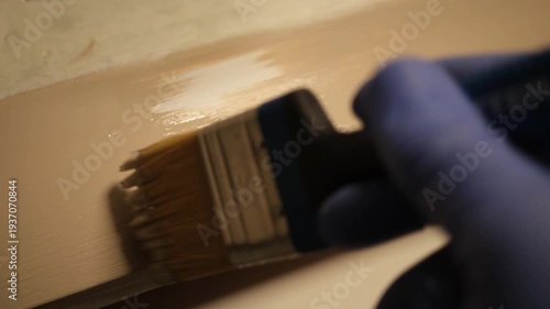 Picture restorer painting a glass frame.