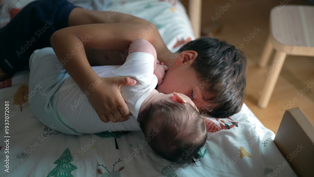 Fototapeta premium Young boy lying on bed holding baby sibling in arms, gentle embrace, sibling bonding, childhood connection, warmth and affection, soft family moment, cozy indoor setting