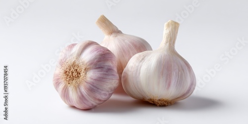 Garlic bulbs arranged on white surface close up studio