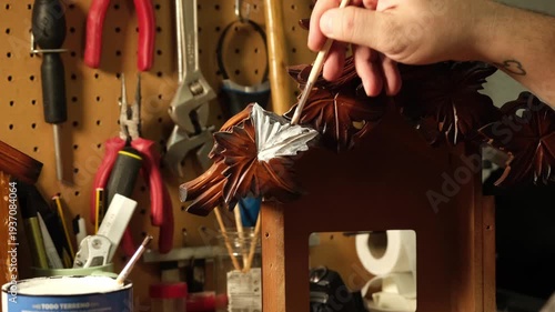Master craftsman painting a piece of wood with a brush.