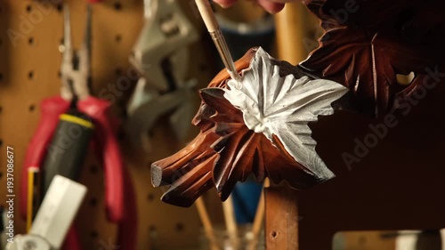 Master craftsman painting a piece of wood with a brush.