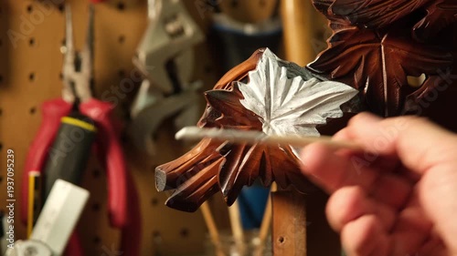 Master craftsman painting a piece of wood with a brush.