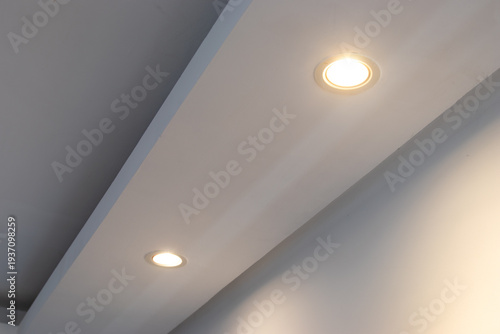 Detail of recessed ceiling lighting with LED spotlights lit in a residential interior. 