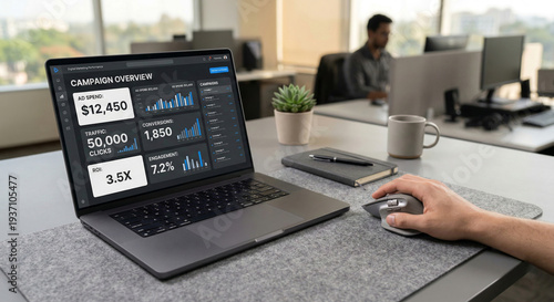 Person working on a laptop displaying a digital marketing campaign overview with ad spend traffic conversions and roi