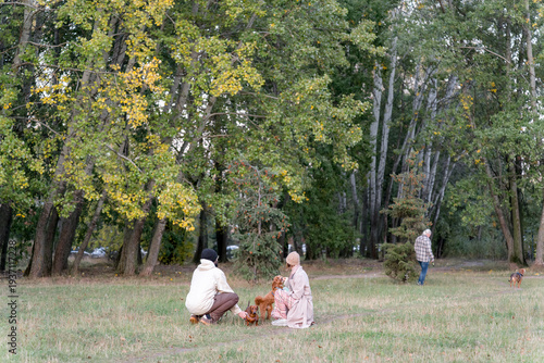 Название:
Happy Couple with Dogs in Autumn Park – Family Pet Lifestyle