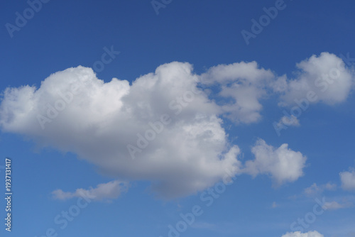 Cloudscape with white fluffy clouds in sunset sky