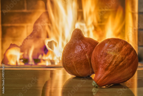 Cozy fireplace,winter vacations, pumpkins on the table, fire burning