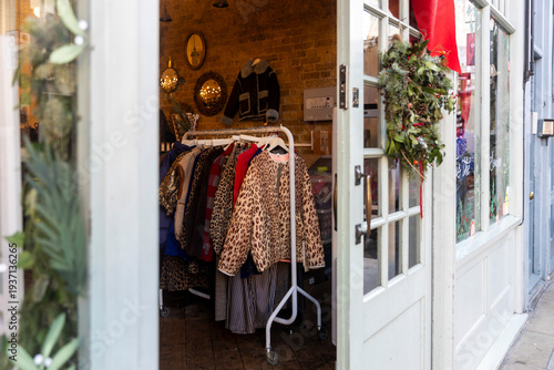 London, UK, 12 December 2026,  Entrance to a cozy vintage clothing boutique decorated with a christmas wreath.
