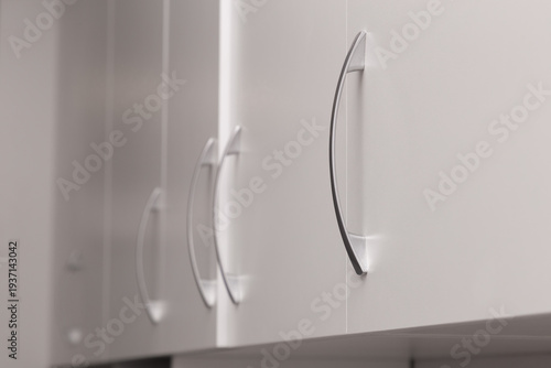 housewife opens kitchen wall cabinet, close-up. housewife opens a kitchen cabinet drawer with her hand. woman's hand opens the kitchen cabinet