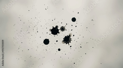 Black ink splatters on a white background with varying sizes and intensity.