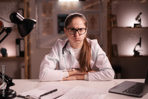Bilde på lerret Portrait of bored resentful doctor woman working late night at hospital